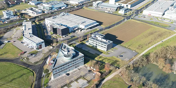 Wirtschaftspark Stadtgut Steyr mit Blick auf das dreieckige TIC Steyr Gebäude in der vorderen Mitte und ein Stadtgutteich rechts, Foto: Erwin Hackl